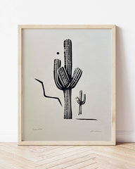 Framed artwork of a black cactus illustration on a light gray background