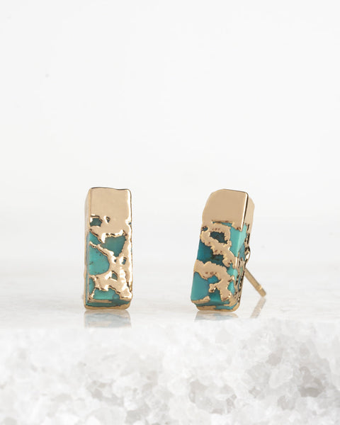 Pair of gold and turquoise earrings on a white background