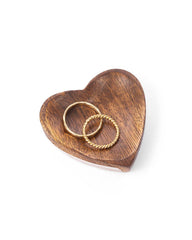 Wooden heart-shaped trinket dish with two gold rings on a white background
