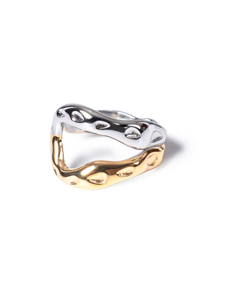 A two-tone wavy ring with a polished silver top band and a gold bottom band, photographed on a clean white background.