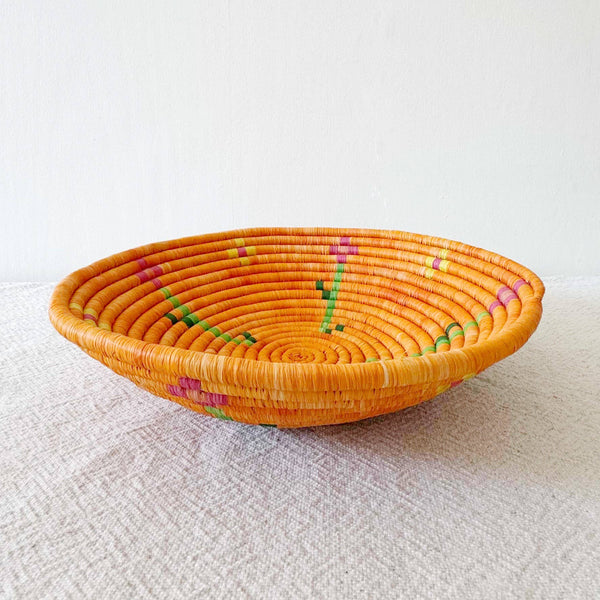 Woven basket with floral patterns on a textured surface