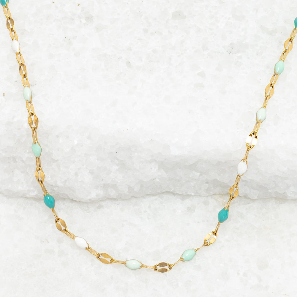 Necklace with gold chain and turquoise beads on a white background