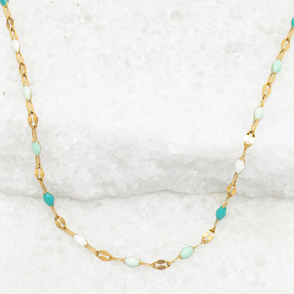 Necklace with gold chain and turquoise beads on a white background