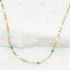 Necklace with gold chain and turquoise beads on a white background
