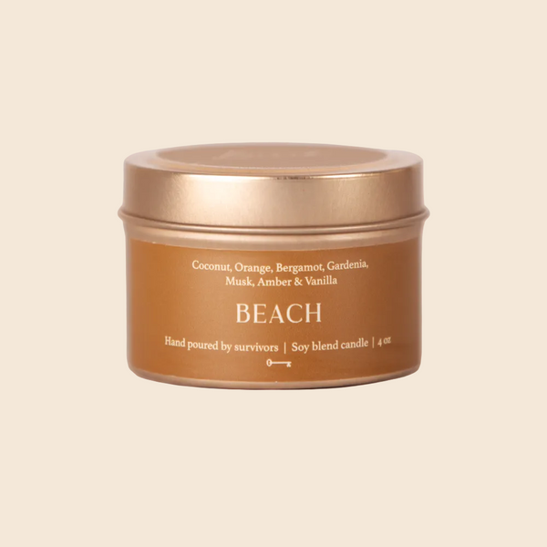 Candle jar labeled 'Beach' with a bronze lid on a white background