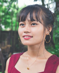 Woman wearing a red top with a blurred green background