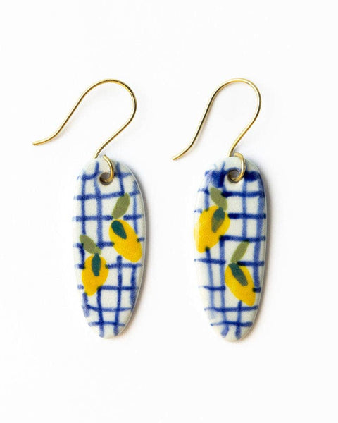 Pair of earrings with blue and white checkered pattern and yellow accents on a white background