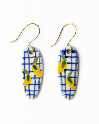 Pair of earrings on a 'INK+ALLOY' branded card against a white background