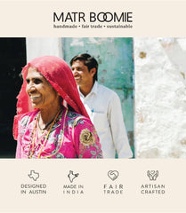 Woman wearing a pink shawl with a man in the background, featuring Matr Boomie branding and product attributes.