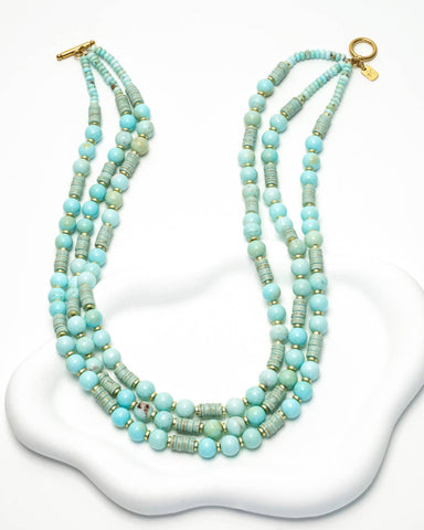 Flowing strands of dreamy turquoise beads come together in this elegant,...
