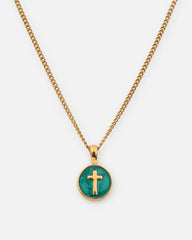 Gold necklace with a green pendant featuring a cross on a white background