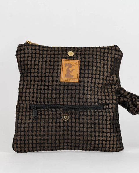 A small black and brown checkered fabric pouch with a wrist strap, a front zipper pocket, and a tan leather brand patch on a white background.