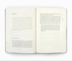 An open book with two cream-colored pages displaying printed text, photographed against a solid white background.