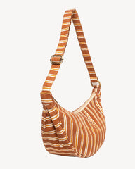 A crescent-shaped shoulder bag with a rust-orange and cream striped pattern, featuring a matching adjustable shoulder strap with a silver buckle, shown against a plain off-white background.