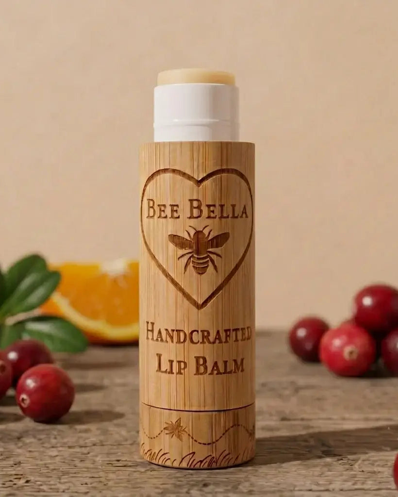 Bee Bella lip balm with wooden container on a rustic surface with cranberries and oranges.