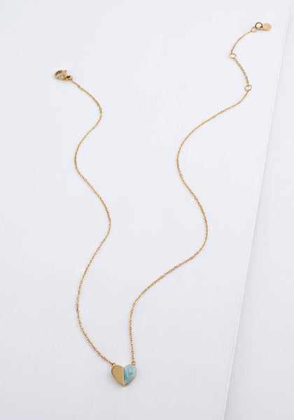 A delicate gold chain necklace with a small heart-shaped pendant featuring a light blue inlay, displayed on a clean white background.