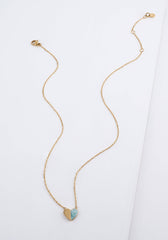 A delicate gold chain necklace with a small heart-shaped pendant featuring a light blue inlay, displayed on a clean white background.