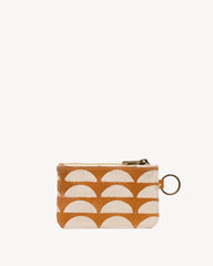 A small zippered pouch with a repeating semi-circular pattern in orange and cream, featuring a gold-tone metal key ring attachment.