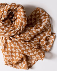 Brown scarf with white leaf pattern on a white background