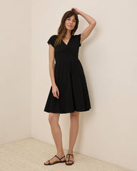 Woman wearing a black dress against a plain background
