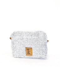 A small woven pouch or cosmetic bag in a light gray and white textured tweed fabric, featuring a small gold-tone metal logo plaque on the front and a tiny gold accent on the side, set against a plain white background.