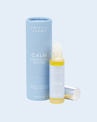 Thistle Farms Calm essential oil roll-on bottle and packaging on a light blue background