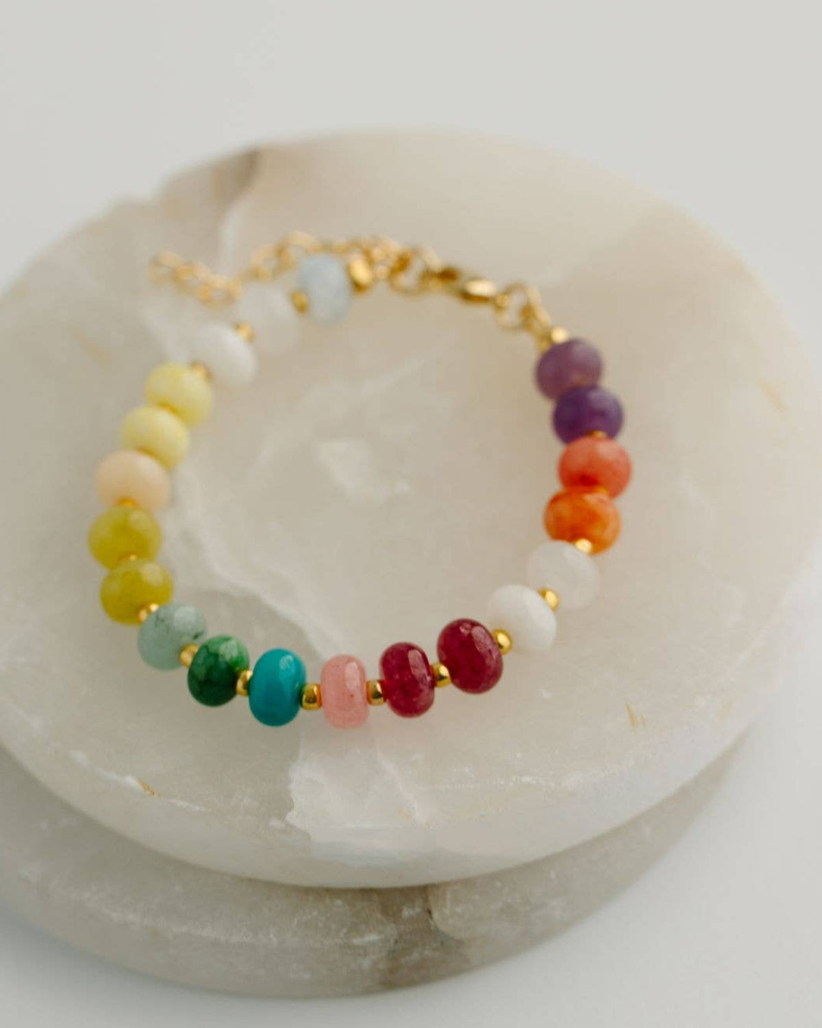Multicolored beaded bracelet on a white stone surface