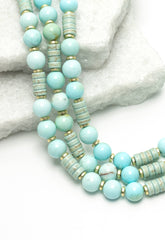 Turquoise beaded necklace on a white stone surface