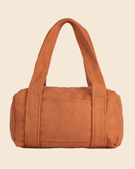 A small cylindrical duffel bag in a textured rust-orange fabric, featuring two top handles, photographed against a neutral light gray background.