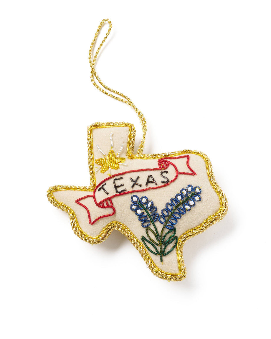 Embroidered ornament shaped like the state of Texas with 'Texas' text and bluebonnet flowers on a white background.