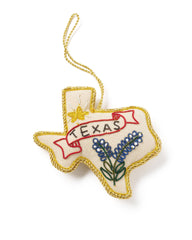 Embroidered ornament shaped like the state of Texas with 'Texas' text and bluebonnet flowers on a white background.