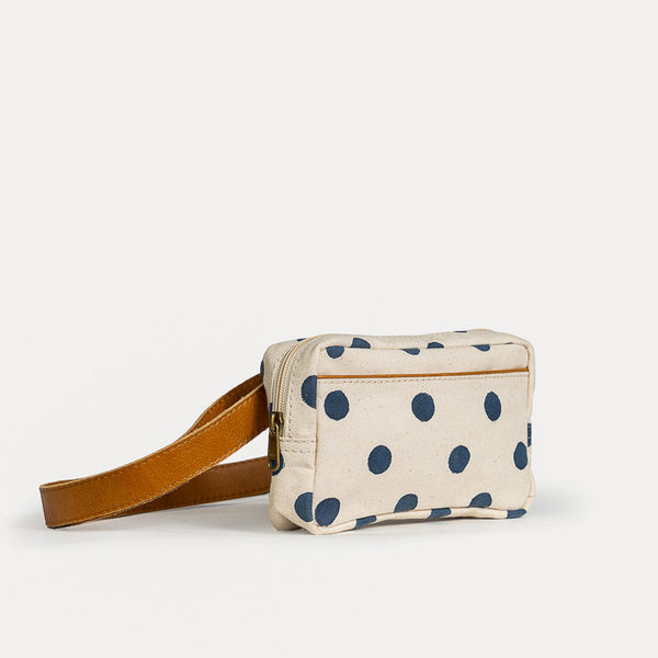 Small pouch with blue polka dots and a brown strap on a white background