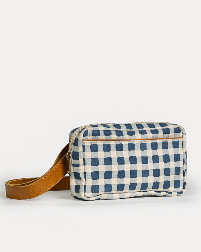 Blue and white checkered bag with a brown strap on a light gray background