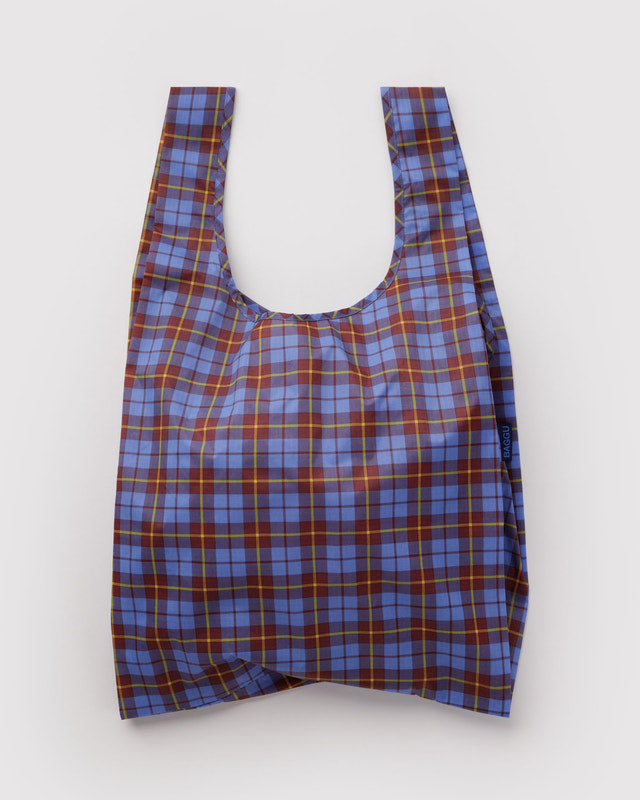 A reusable plastic bag with a blue, purple, and red plaid pattern, photographed flat against a light gray background.