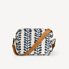 Crossbody bag with leaf pattern and brown strap on a white background