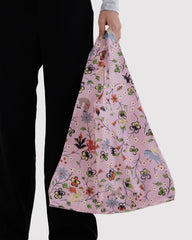 Person holding a floral-patterned bag against a white background