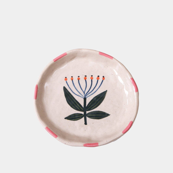 Round ceramic dish with floral design on a light gray background