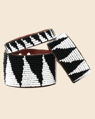 Three wide beaded bracelets with a black and white geometric triangle pattern, arranged on a light blue background.