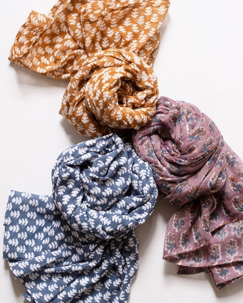 Three patterned scarves in orange, blue, and pink on a white background