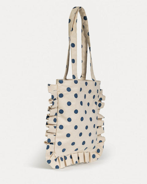 Beige tote bag with blue polka dots and ruffled edges on a white background