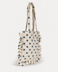 Beige tote bag with blue polka dots and ruffled edges on a white background