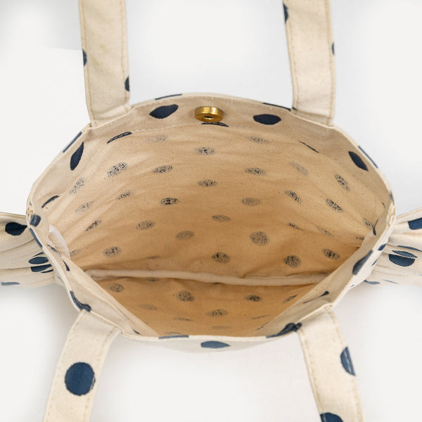 Polka dot bag with beige interior on a white background