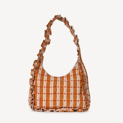 Plaid handbag with ruffled details on a white background