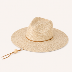 Beige straw hat with a brown band and tassel on a light beige background