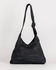 A black textured slouchy shoulder bag with a single strap, photographed against a plain white studio background.