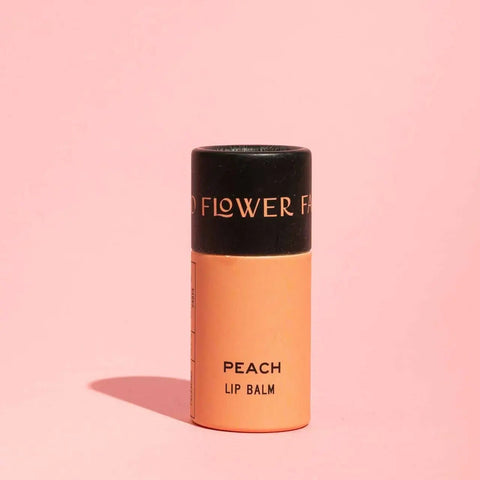 Woman applying lip balm with a neutral background