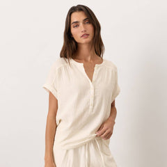 Woman wearing a cream-colored outfit on a white background