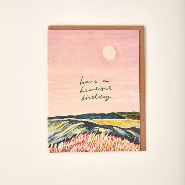 Greeting card with landscape illustration and 'Have a Beautiful Birthday' text on a pink background.