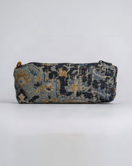 A rectangular zippered pouch with a woven, distressed tapestry pattern in navy blue, beige, and gold, shown against a plain light gray background.
