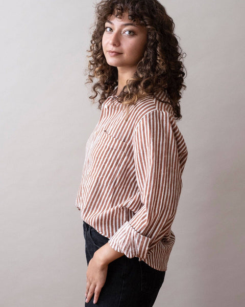Woman wearing a striped shirt against a plain background